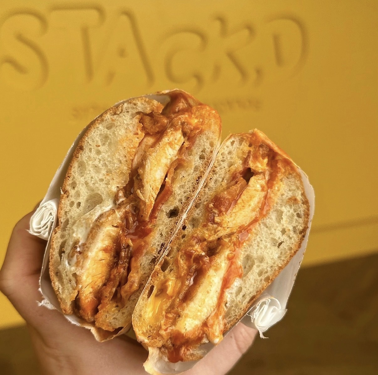 A STACKD chicken sandwich wrapped and ready to take away